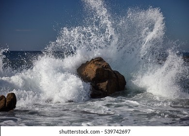 splits waves against rocks in the sea