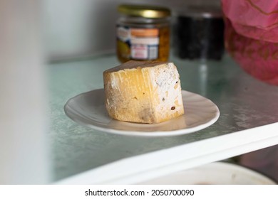 Spoiled Cheese Covered With Mold On A Shelf In The Refrigerator.