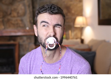 Spoiled Grown Up Man Licking A Pacifier To Control A Tantrum