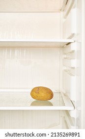 Spoiled Potato Is On The Shelf Of An Empty Refrigerator. Food Shortage, Vertical Format