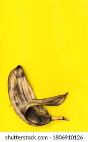 Spoiled Rotten Banana, Peel Isolated On Yellow Background With Copy Space.