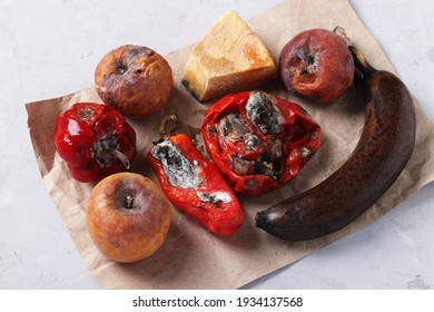 Spoiled Rotten Foods With Mold: Apples, Peppers, Hard Cheese And Banana On Gray Background