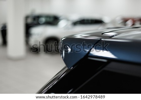 The spoiler of the car. The background is blurred. Classic blue color. Car detail. Exterior detail