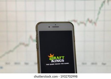 Spokane, WA - USA - February 2021 - Draft Kings App On A Smart Phone, Stock Chart In The Background. Draft Kings Is An American Daily Fantasy Sports Content Provider