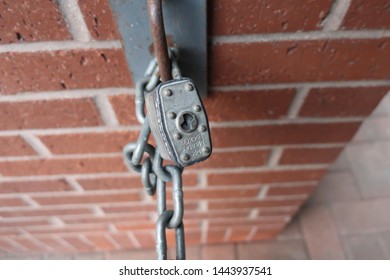 Spokane, Washington - June 29 2019: Close Up Of A Generic Master Lock Padlock With Chain On A Brick Wall.   