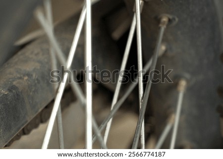 The spokes of a motorcycle wheel. The repeating pattern and radial arrangement of the spokes create an interesting visual.