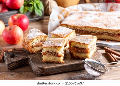 Sponge cake with apples on a wooden board on the table. Homemade pie