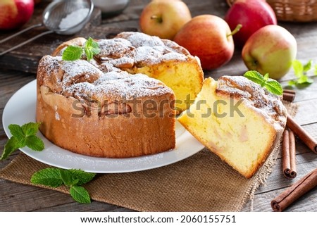 Sponge cake or chiffon cake with apples, so soft and delicious with ingredients: eggs, flour, apples on wooden table. Homemade bakery concept for background and wallpaper.