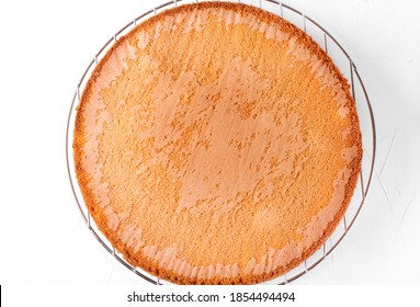 Sponge Cake Cooling Down On The Pastry Lattice Against The White Background. Top View