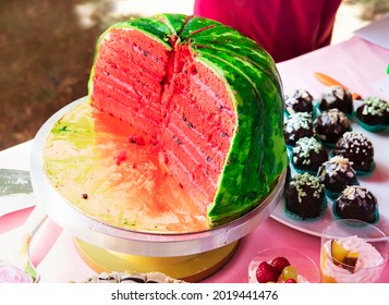 Sponge Cake With Cream In The Shape Of A Watermelon On A Cake Dish On A Food Court And Cakes With Fruit. Sliced Watermelon Cake With Seeds At The Harvest Festival. Funny Handmade Culinary Masterpieces