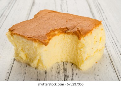 Sponge Cake On White Wood Background With A Bite