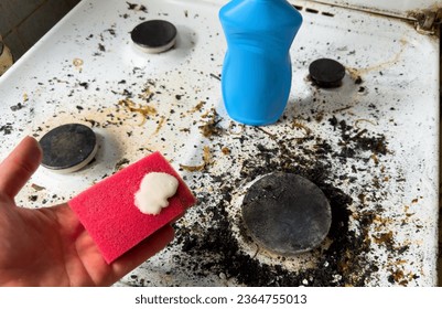 Sponge with detergent and foam while washing the gas stove on kitchen. Wash dishes and plumbing. Sponges for wash and cleaning of dirty. Removing grease with detergents and anti-bacterial liquids - Shutterstock ID 2364755013
