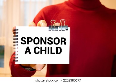 Sponsor A Child Text Written On A Notebook With Pencils.