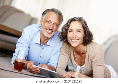 Spontaneity is the spice of life. Portrait of a happy mature couple lying on the floor and using a digital tablet. - Shutterstock ID 2134321193