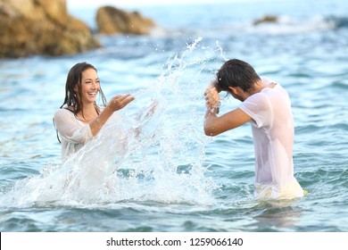 Spontaneous Couple Joking Throwing Water Bathing In The Sea On The Beach