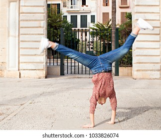 Spontaneous Young Woman Sightseeing On City Holiday, Doing Cartwheel At Stone Monument, Expression Of Joy, Outdoors. Teenager Celebrating Dynamic Energy Fun, Travel Recreation Leisure Lifestyle.