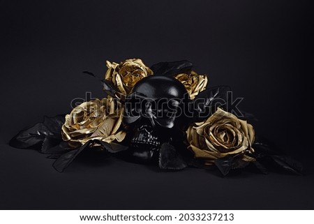 Spooky black human skull surrounded with golden roses and black leaves isolated on a black background. Creative Halloween or Santa Muerte concept. Minimal romantic dark aesthetic wallpaper.