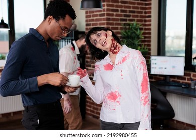 Spooky Evil Zombie Talking To Man At Workplace, Macabre Cruel Monster Corpse In Business Office Acting Aggressive And Dangerous. Scary Undead Devil With Bloody Wounds In Company Space.