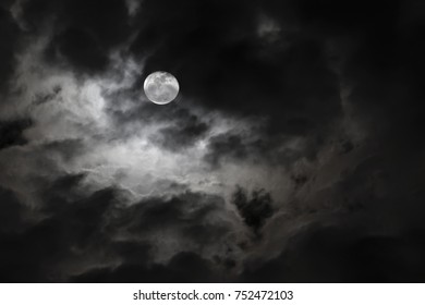 Spooky Full Moon And Eerie White Clouds Against A Black Night Sky