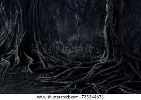 Spooky Halloween dead mysterious forest creepy trees with twisted roots and two lizard on misty night forest. Scary concept.