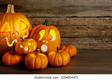 Spooky Jack O`lanterns On Wooden Table, Space For Text. Halloween Decor