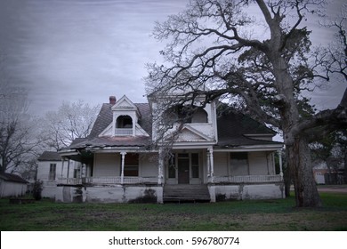 Spooky Old Haunted House With A Dead Tree In The Yard In Rural Texas. 