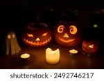 Spooky season halloween decor. Carved pumpkins by miniature ghost and child Jack-o