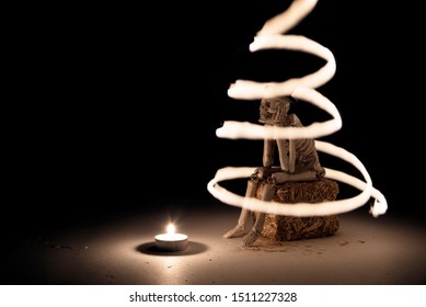 Spooky skeleton sitting on a haystack at dark.