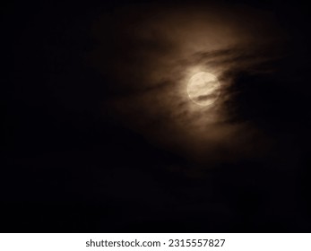 spooky yellowish full moon and dark clouds