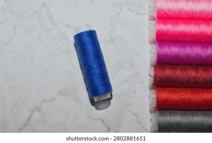 spool of blue and multicolored sewing thread