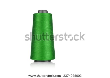 spool of industrial thread green color, texture of thread on a white background close-up
