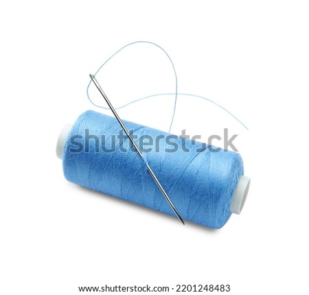 Spool of light blue sewing thread with needle isolated on white
