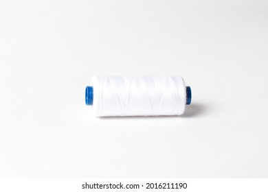 A spool of white thread. White background.