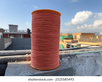 Spools thread charkhi for kite flying on the wall with cloudy sky in the background, kites festival
