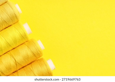 Spools of thread on yellow background