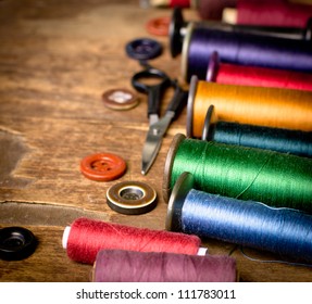 Spools of threads and buttons on old wooden table - Powered by Shutterstock