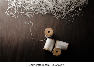 spools of white thread over a black background