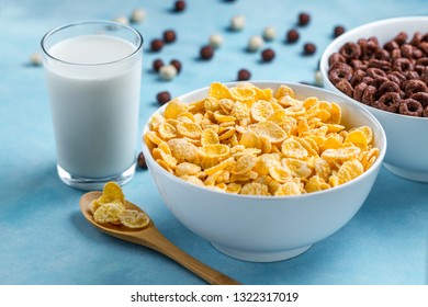 Spoon And Bowl With Chocolate Rings, Yellow Frosted Corn Flakes And A Glass Of Milk For Dry, Cereals Breakfast 