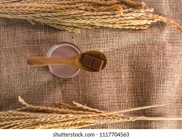 Spoon With Chocolate Bar Placed On Glass Of Chocolate Malt Milk On Sackcloth, Top View