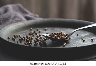 A Spoon And Cilantro Placed On A Black Iron Plate. Image Of Spices. Close-up.