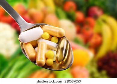 spoon with dietary supplements on fruits background