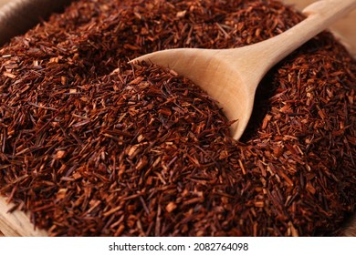 Spoon Dry Rooibos Leaves In Wooden Bowl, Closeup