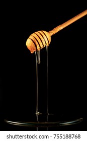 Spoon Of Honey. On A Black Background. Dripping Fresh Honey.