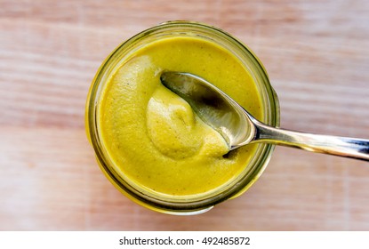 A Spoon In A Jar Of Dijon Mustard