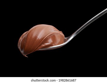 spoon of melted chocolate hazelnut cream on black background