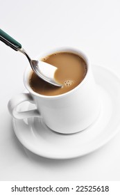 Spoon Mixing A Cup Of Coffee With Cream.