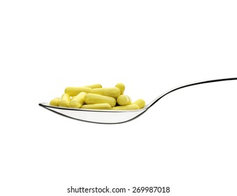 Spoon and pills front view. White background. Clipping path