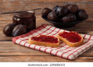 Spoon with plum jam on retro decorated desk with Fruit and glass jar Close up, selective focus and copy space, Plum jam in a jar.  Breakfast from homemade plum jam bread and fresh ripe plums fruits. - Powered by Shutterstock