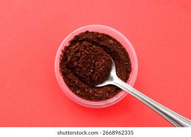 Spoon with a portion of ground coffee
