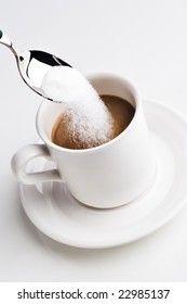 Spoon Pouring Sugar Into A Cup Of Coffee